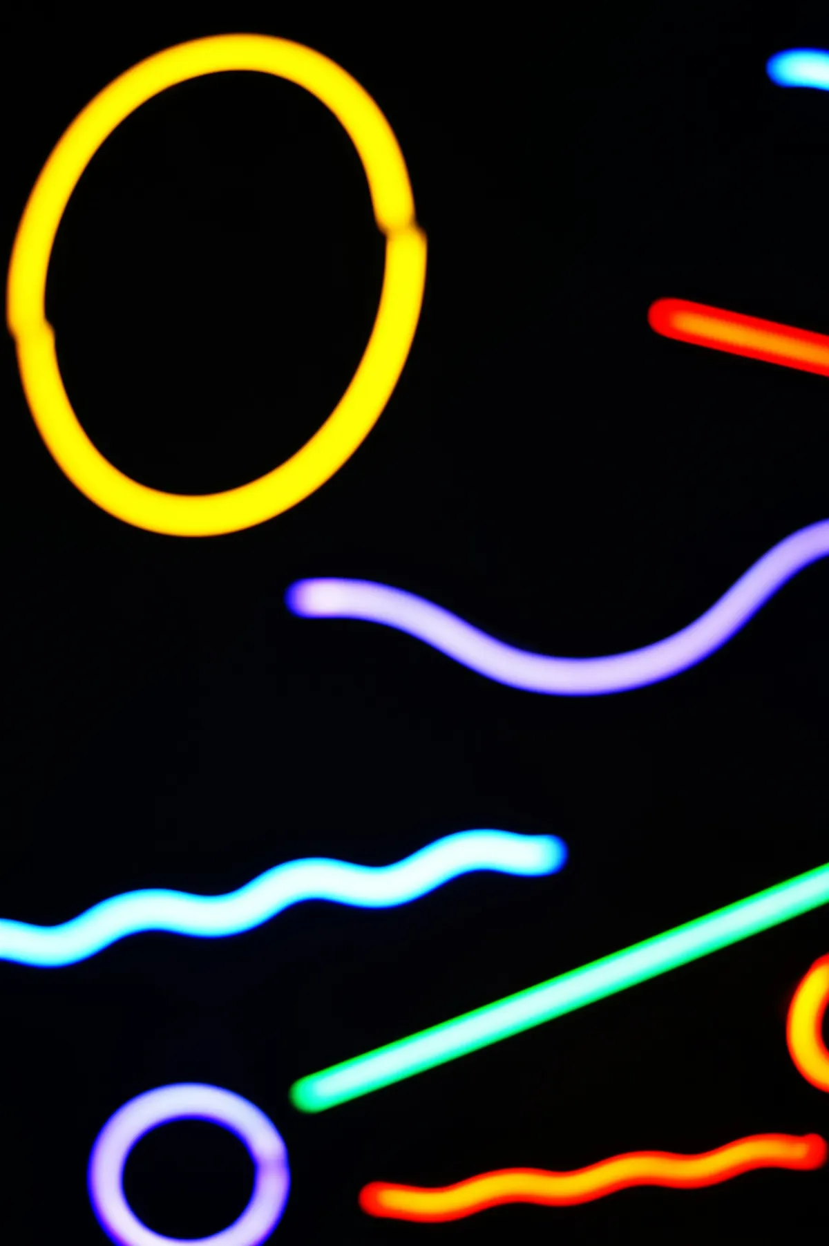 Detalle de trazos luminosos de distintos colores sobre un fondo oscuro.